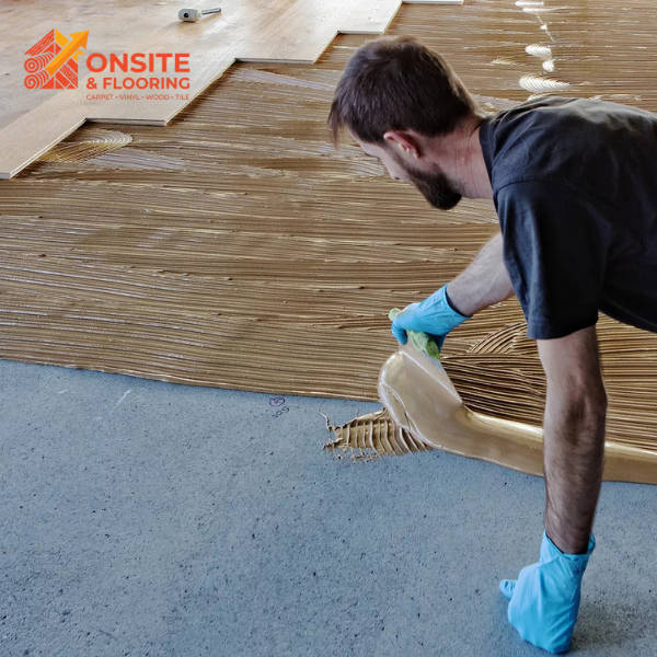 Master flooring installer applying adhesive for precision floor installation